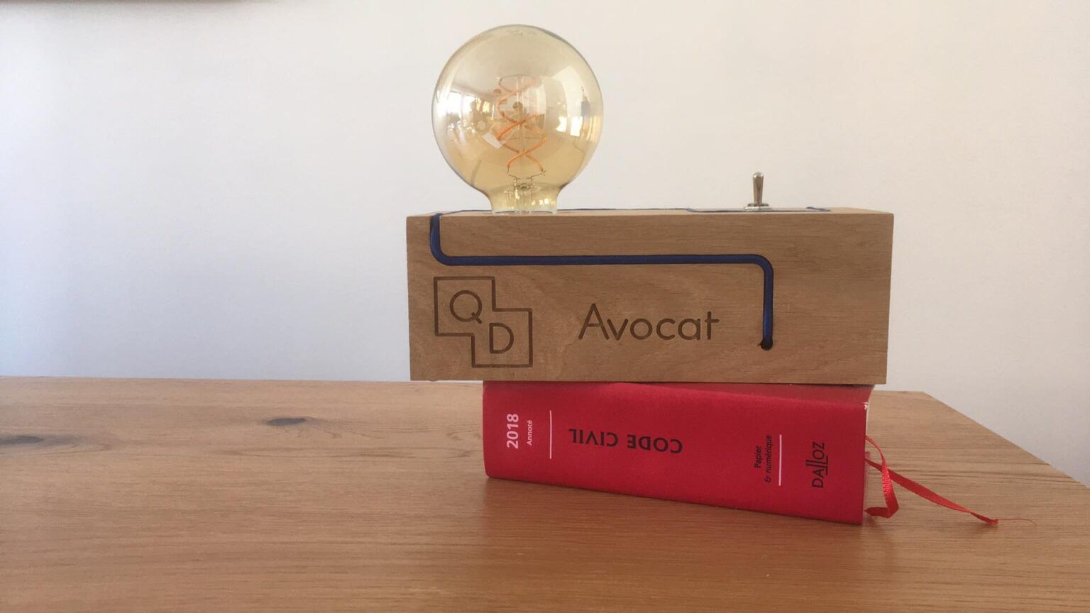 La lampe QD Avocat posée sur le Code civil, au cabinet